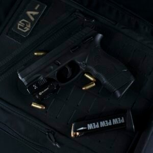 A black handgun and bullets on a tactical backpack, ideal for security and defense concepts.