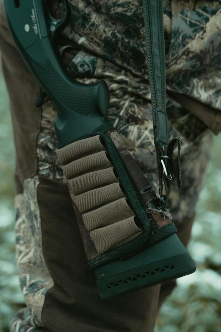 Close-up of a rifle with ammunition holder and camouflage clothing, perfect for hunting themes.